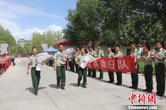 部隊官兵們迎接出院歸來的李運飛(中)和其他消防戰(zhàn)士。　汪渝 攝