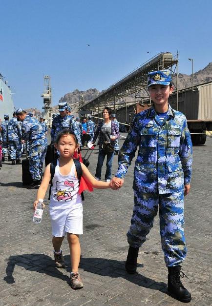 2015年3月，也門，海軍女戰(zhàn)士牽著一名小女孩的手準備登上軍艦。