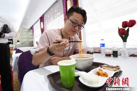 圖為旅客在列車上享用正宗牛肉面?！钇G敏 攝