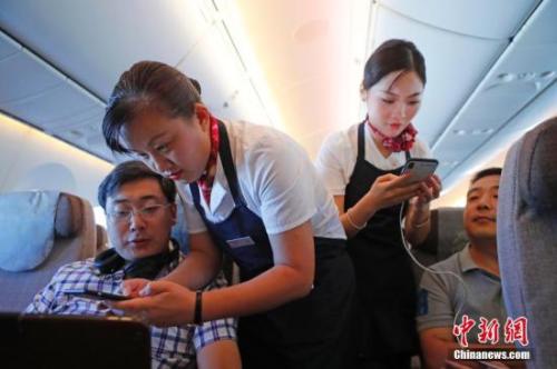 資料圖：乘務(wù)員們?cè)诳团搩?nèi)為旅客調(diào)試機(jī)上上網(wǎng)功能。<a target='_blank' ><p  align=