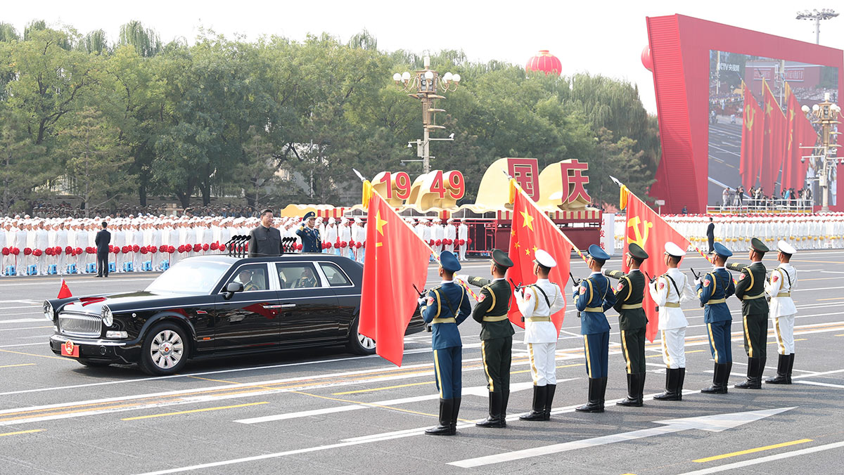 習(xí)近平驅(qū)車行進(jìn)至黨旗、國旗、軍旗前，向旗幟行注目禮