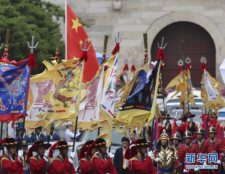 7月3日，韓國總統(tǒng)樸槿惠在青瓦臺總統(tǒng)府舉行隆重儀式，歡迎中國國家主席習(xí)近平對韓國進(jìn)行國事訪問。這是習(xí)近平的車隊(duì)在身著民族服裝的韓國禮儀隊(duì)伍引導(dǎo)下駛?cè)肭嗤吲_。新華社記者丁林?jǐn)z  