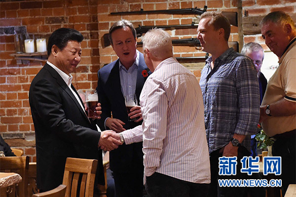 這是習(xí)近平與卡梅倫飲啤酒，并同當(dāng)?shù)孛癖娊徽劇Ｐ氯A社記者 饒愛民 攝